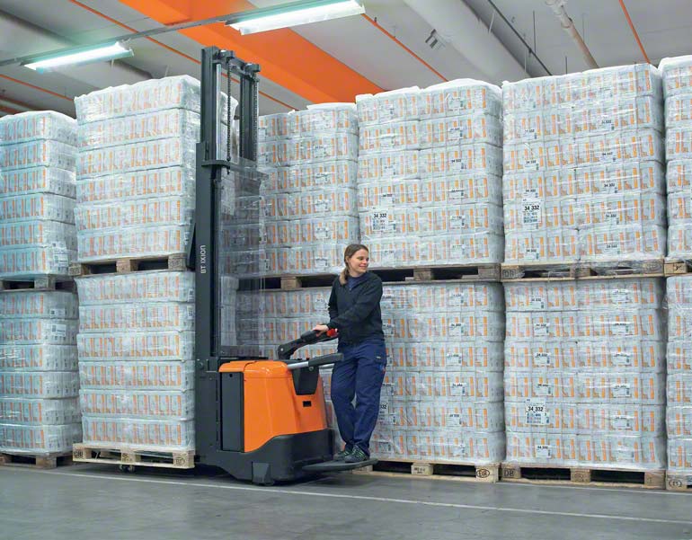 The operator rides the electric pallet truck to carry out warehouse tasks. 