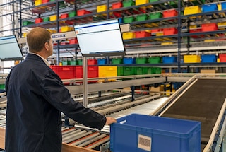 The bins arrive at the pick station via the conveyors