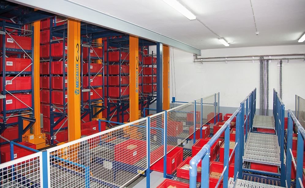 A twin-mast stacker crane circulates in each aisle with double forks