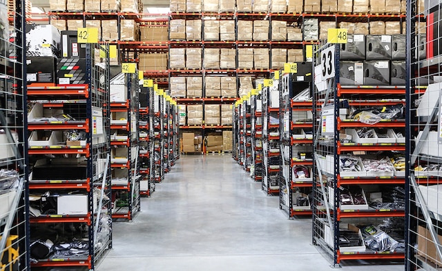 This warehouse composed of pallet racking, picking shelves for boxes and a conveyor circuit that includes a sorting zone