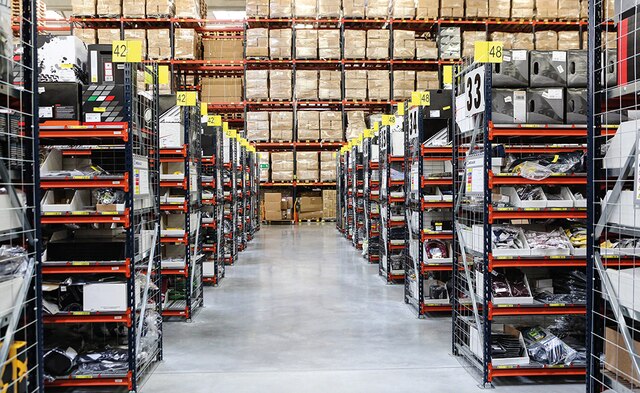 This warehouse composed of pallet racking, picking shelves for boxes and a conveyor circuit that includes a sorting zone